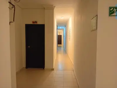 a hallway with a black door and a tile floor at Hotel Girasol Inn Barranquilla in Barranquilla