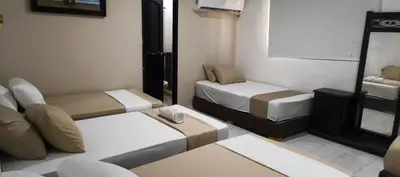 a small room with two beds and a tv at Hotel Girasol Inn Barranquilla in Barranquilla