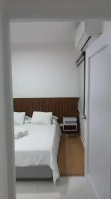 a bedroom with a white bed and an open door at Hermoso apartamento in Cartagena de Indias