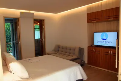 a bedroom with a bed and a couch and a television at Fotosíntesis - Apartamento frente al mar en Tolú in San Silvestre