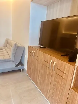a flat screen tv sitting on top of a wooden entertainment center at Fotosíntesis - Apartamento frente al mar en Tolú in San Silvestre