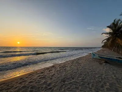 a boat sitting on the beach at sunset at Cabaña Tierramia 2 in San Silvestre
