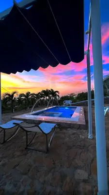 a table and an umbrella with a sunset in the background at Liz&Mar in El Morro