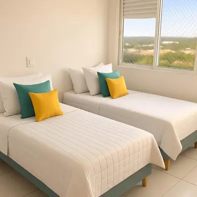 two beds with yellow and blue pillows in a room at Stunning 2BD Apartment Pool - Oceanview Cartagena in Cartagena de Indias