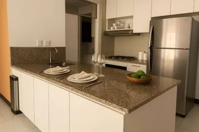 a kitchen with a counter with a sink and a refrigerator at Stunning 2BD Apartment Pool - Oceanview Cartagena in Cartagena de Indias