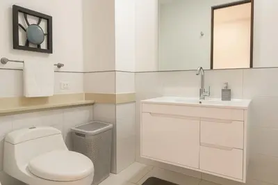 a white bathroom with a toilet and a sink at Stunning 2BD Apartment Pool - Oceanview Cartagena in Cartagena de Indias
