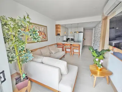 a living room with a white couch and a kitchen at Apart Suítes Stay Morros EOS - Acceso directo a la playa in Cartagena de Indias