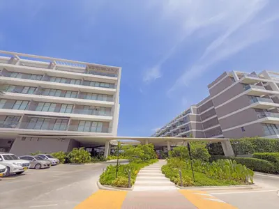 a large building with cars parked in a parking lot at Apart Suítes Stay Morros EOS - Acceso directo a la playa in Cartagena de Indias