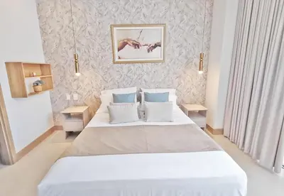 a bedroom with a large white bed with blue pillows at Apart Suítes Stay Morros EOS - Acceso directo a la playa in Cartagena de Indias