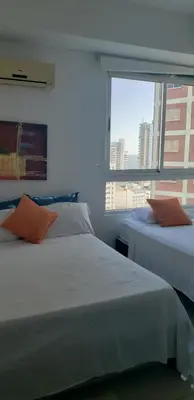 two beds in a room with a window at Palmetto Eliptic Bahia in Cartagena de Indias