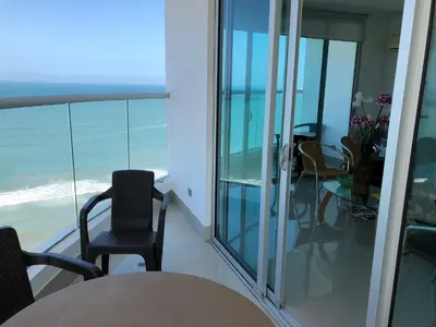 a living room with glass doors and a table and chairs at Palmetto Eliptic Bahia in Cartagena de Indias