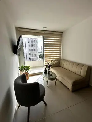 a living room with a couch and a chair and a window at Apartamento Económico en Cartagena in Cartagena de Indias