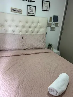 a pink bed with a white pillow on top of it at Apartamento Económico en Cartagena in Cartagena de Indias