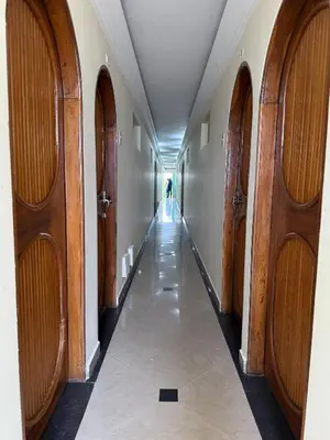 a hallway with wooden doors and a person walking down it at Hotel San Francisco Inn in Barranquilla