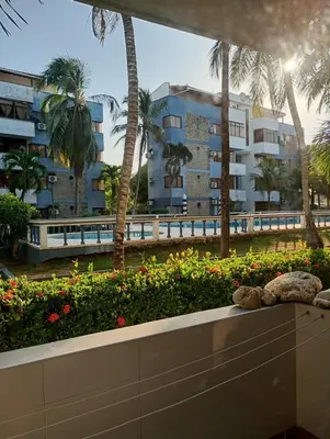 a view of a building with palm trees and flowers at Vikingos de Tolú, a un Salto de las Islas in Tolú