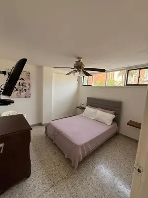 a bedroom with a bed and a ceiling fan at Barrio El Golf Apartment in Barranquilla