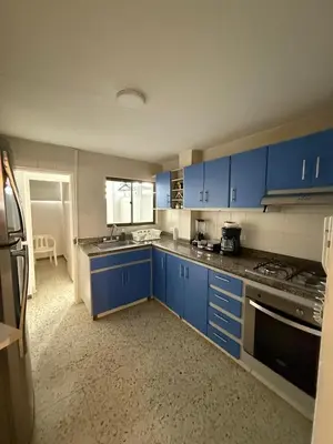 a kitchen with blue cabinets and a stove top oven at Barrio El Golf Apartment in Barranquilla