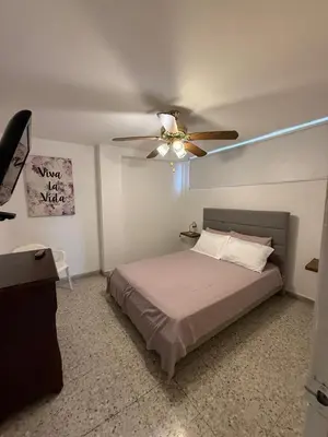 a bedroom with a bed and a ceiling fan at Barrio El Golf Apartment in Barranquilla