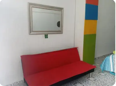 a red couch in a room with a mirror at Getsemani ballestrinqe in Cartagena de Indias