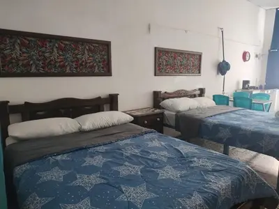 two beds in a room with blue and white sheets at Getsemani ballestrinqe in Cartagena de Indias