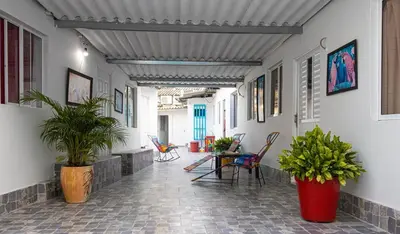 a hallway with a table and chairs and plants at Getsemani ballestrinqe in Cartagena de Indias