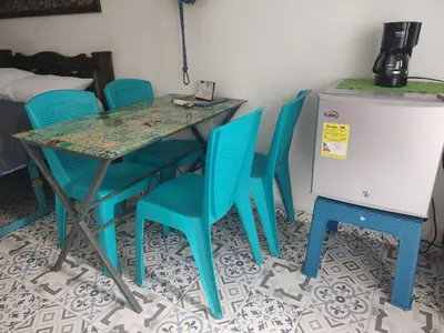 a table with blue chairs and a table with a refrigerator at Getsemani ballestrinqe in Cartagena de Indias