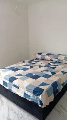 a bed with a blue and white comforter on it at Edificio Lotus Torices Cartagena in Cartagena de Indias