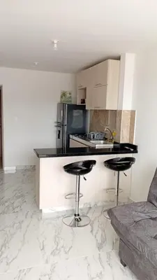 a kitchen with a counter and two bar stools at Edificio Lotus Torices Cartagena in Cartagena de Indias