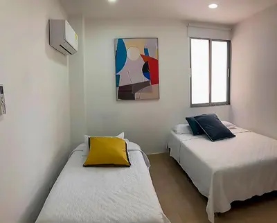 a room with two beds and a painting on the wall at Vive 801 in Cartagena de Indias