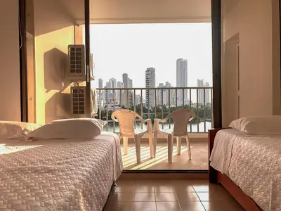 a bedroom with two beds and a balcony with a view at Vive 801 in Cartagena de Indias