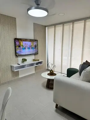 a living room with a couch and a flat screen tv at Baluarte de caribe 212 in Cartagena de Indias