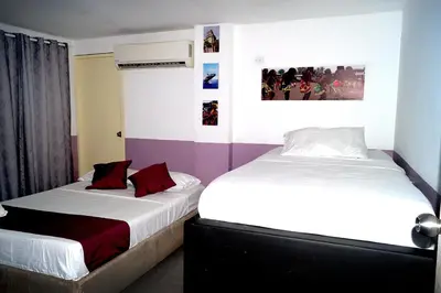 two beds in a hotel room with two bedsskirts at Dilla House in Cartagena de Indias