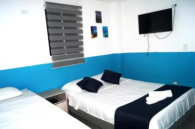a bedroom with two beds and a flat screen tv at Dilla House in Cartagena de Indias