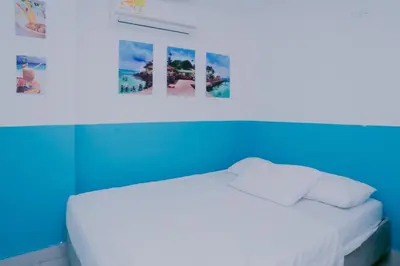 a room with a white bed with a blue wall at Dilla House in Cartagena de Indias