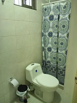 a bathroom with a toilet and a shower curtain at Dilla House in Cartagena de Indias