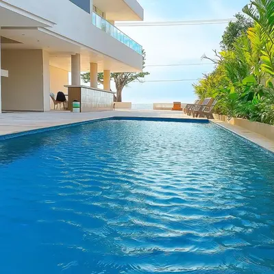 a swimming pool in front of a house at Stanza Del Mar in Coveñas
