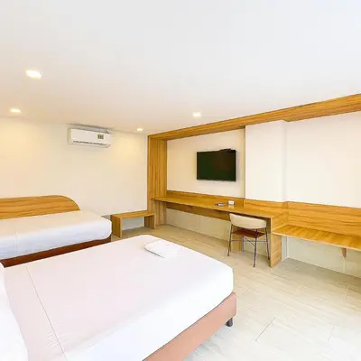 a hotel room with two beds and a tv at Stanza Del Mar in Coveñas