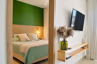 a bedroom with a bed with a green wall at Lujo y comodidad en Baia Kristal, Cartagena in Cartagena de Indias