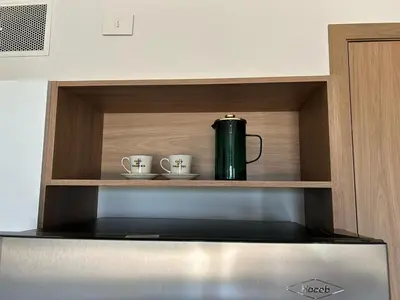 a coffee pot and two cups on a shelf above a stove at Lujo y comodidad en Baia Kristal, Cartagena in Cartagena de Indias