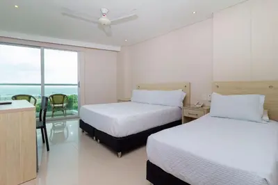 a hotel room with two beds and a balcony at Hotel Summer Frente Al Mar in Cartagena de Indias