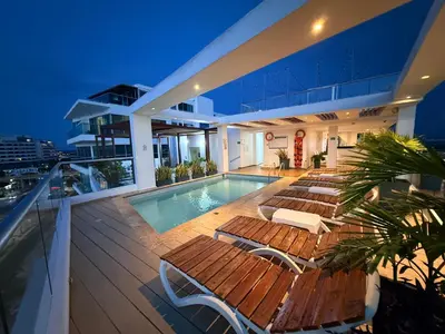a house with a swimming pool and chairs on a deck at Hotel Summer Frente Al Mar in Cartagena de Indias