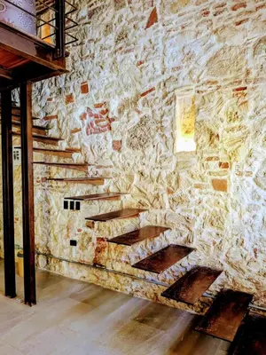 a stone wall with wooden stairs in a room at Duplex Colonial Getsemani in Cartagena de Indias