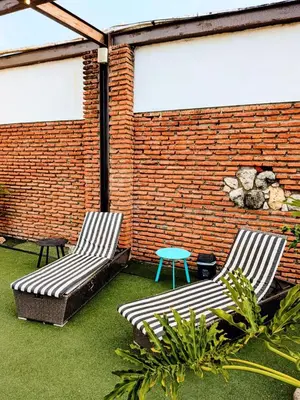 two chairs and a table and a brick wall at Duplex Colonial Getsemani in Cartagena de Indias