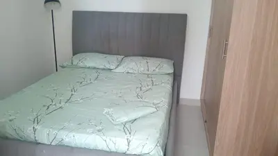 a bed with green sheets and pillows in a room at APTO A 5 MIN CAMINANDO PLAYAS DE MARBELLA y A 20 MIN DE MURALLAS in Cartagena de Indias