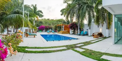 a backyard with a swimming pool and palm trees at Casa Romero Cartagena Casa de Playa in Cartagena de Indias