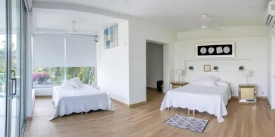 a white room with two beds and a window at Casa Romero Cartagena Casa de Playa in Cartagena de Indias