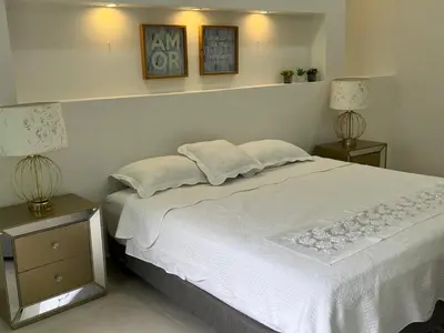 a bedroom with a large white bed with two lamps at Casa Romero Cartagena Casa de Playa in Cartagena de Indias