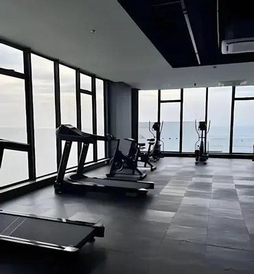 a gym with cardio equipment in a room with windows at Spectacular apartment, unparallel views! in Cartagena de Indias