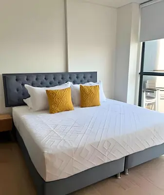 a bedroom with a large bed with yellow pillows at Spectacular apartment, unparallel views! in Cartagena de Indias