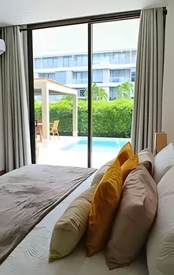 a bedroom with a bed with pillows and a large window at Exclusivo Apto, Piscina Privada y Salida a playa in Cartagena de Indias